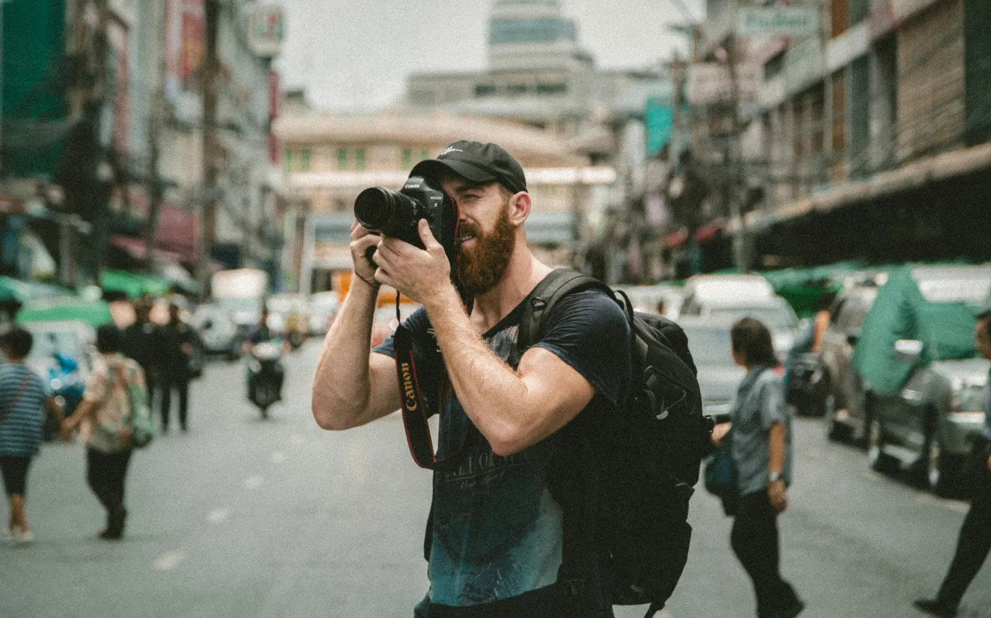 shallow focus photography of man using a DSLR camera by Jakob Owens courtesy of Unsplash.