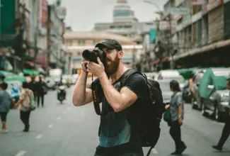 shallow focus photography of man using a DSLR camera by Jakob Owens courtesy of Unsplash.